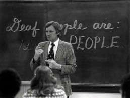 Photo of Little during a presentation entitled 