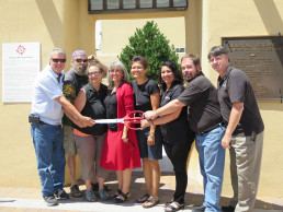 Photo of Dr. Gallegos & Alumni at Ribbon Cutting for the completed construction project that included the Health Center archway, elementary playing field and pavilion.